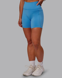 Woman wearing Fusion Ultra High-Rise 6" Short Pockets - Azure Blue | Set:true | Angle:side | Model:Amber | Size:S