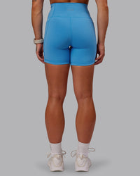 Woman wearing Fusion Ultra High-Rise 6" Short Pockets - Azure Blue | Set:true | Angle:back | Model:Amber | Size:S