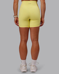 Woman wearing Fusion Ultra High-Rise 6" Short Pockets - Lemon Fizz | Set:true | Angle:back | Model:Amber | Size:S