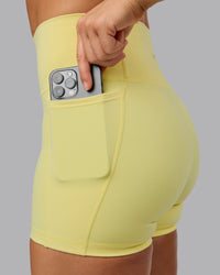 Woman wearing Fusion Ultra High-Rise 4" Short Pockets - Lemon Fizz | Model:Shalem | Size:S | Thumbnail Index: 1