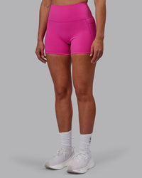 Woman wearing Fusion Ultra High-Rise 4" Short Pockets - Fuchsia Pink | Set:true | Angle:side | Model:Sophie | Size:S