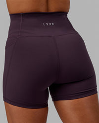 Woman wearing Fusion Ultra High-Rise 4" Short Pockets - Midnight Plum | Model:Gabby | Size:S