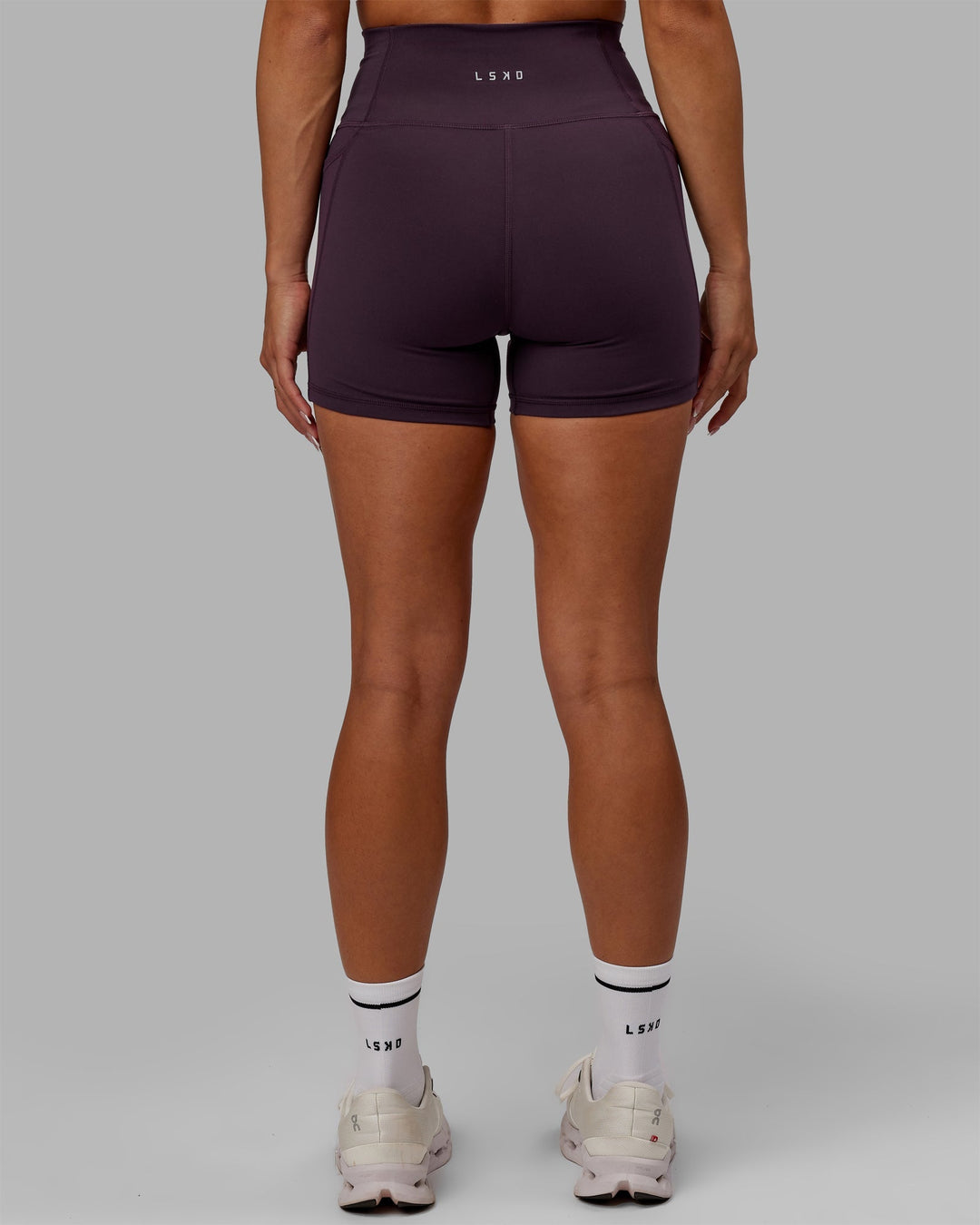 Woman wearing Fusion Ultra High-Rise 4" Short Pockets - Midnight Plum | Model:Gabby | Size:S