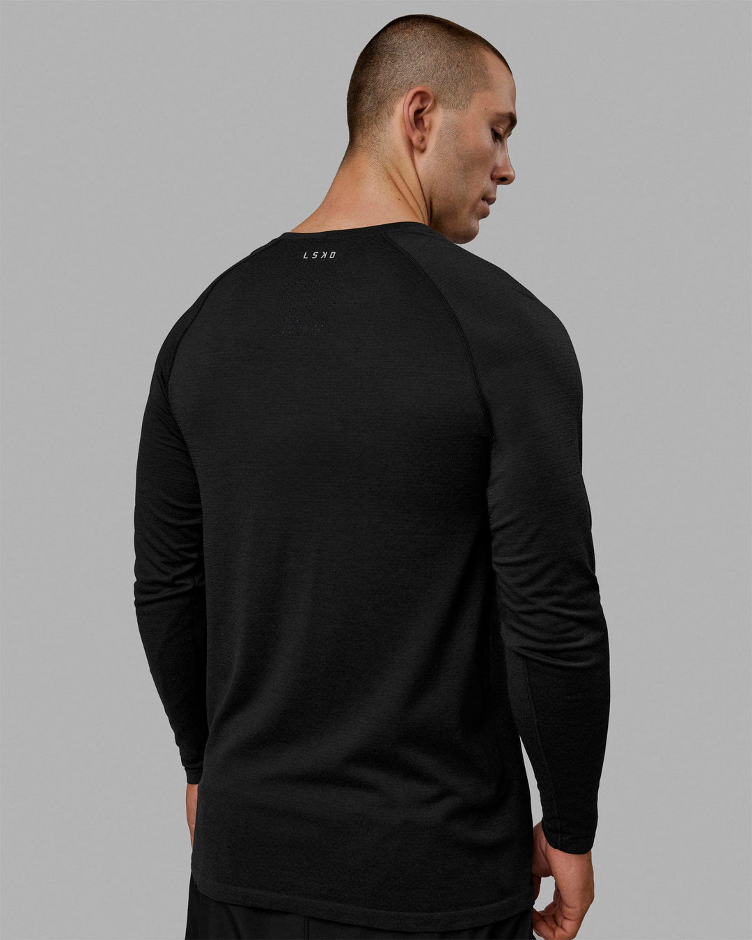 Man wearing AeroFLX+ Seamless Long Sleeve Tee - Black Marl