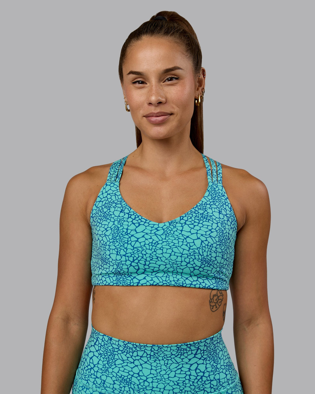 Woman wearing Push The Limit Sports Bra - Aquatic Awe Vitality Print