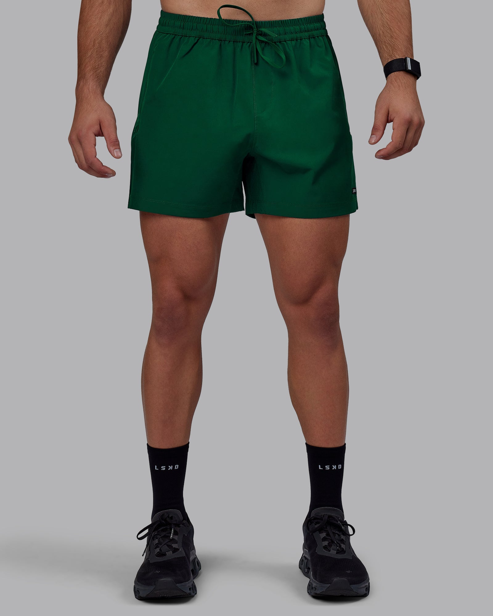 Man wearing Rep 5" Performance Shorts - Deep Emerald