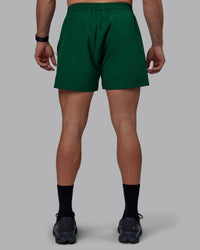 Man wearing Rep 5" Performance Shorts - Deep Emerald