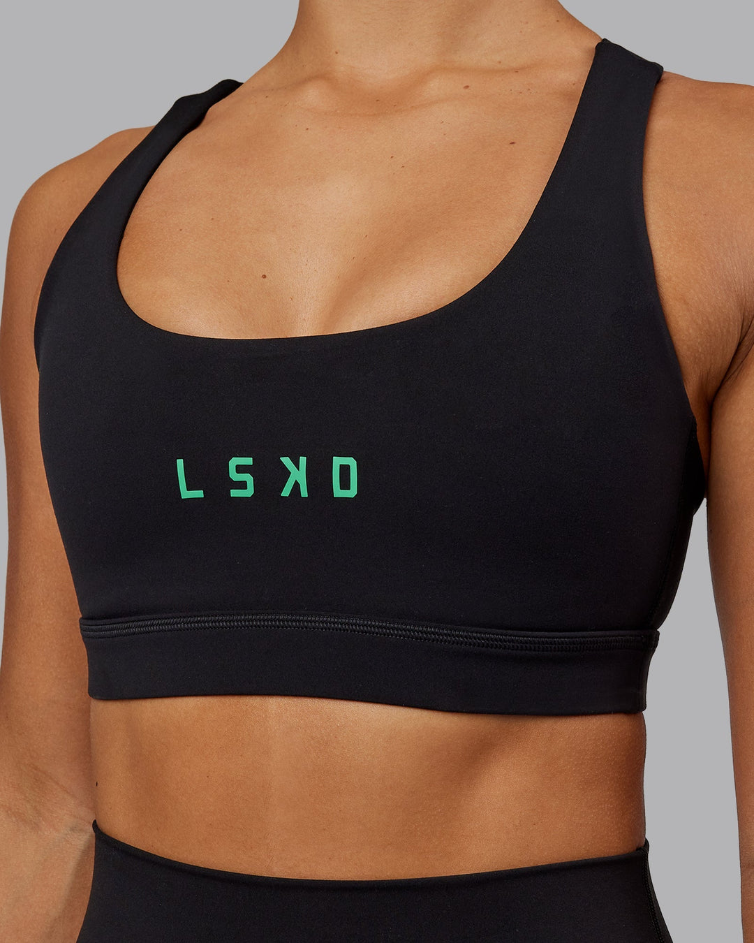 Woman wearing Rep Sports Bra - Black-Impact Green