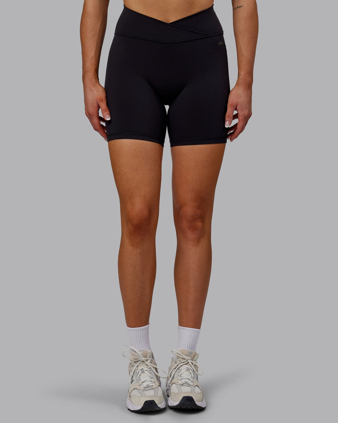 Woman wearing Sara Strike Cross Over Waist Mid-Length Shorts - Black