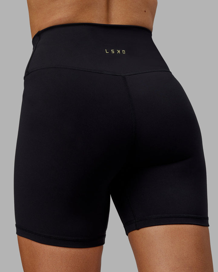 Woman wearing Sara Strike Cross Over Waist Mid-Length Shorts - Black
