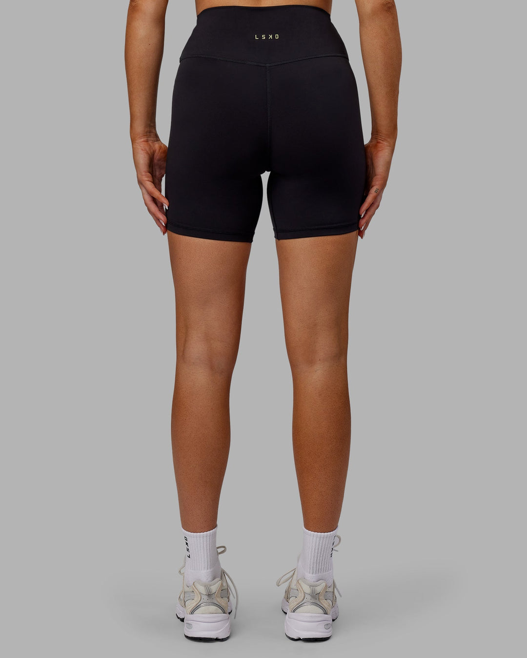 Woman wearing Sara Strike Cross Over Waist Mid-Length Shorts - Black