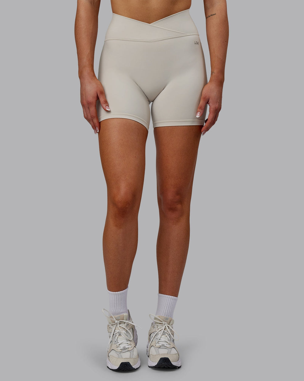 Woman wearing Sara Strike Cross Over Waist Mid-Length Shorts - Shale Beige