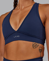 Woman wearing Stamina Sports Bra - Future Navy | Set:true | Angle:closeup | Model:Vanessa | Size:S