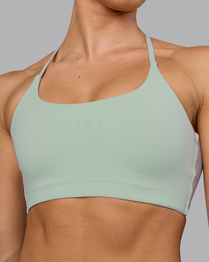 Woman wearing Twist Sports Bra - Surf Spray
