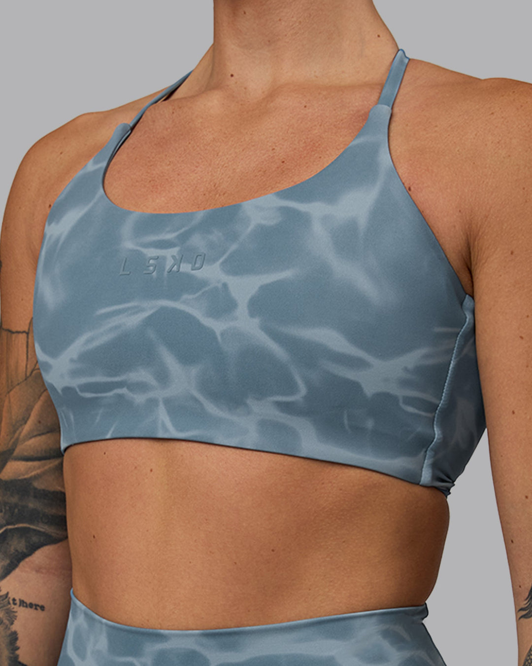 Woman wearing Twist Sports Bra - Tranquil-Elemental Blue