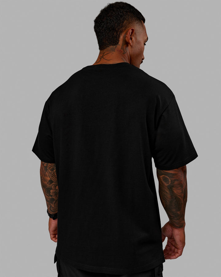 Man wearing Unisex 1% Better FLXCotton Tee Oversize - Black-Scarlet