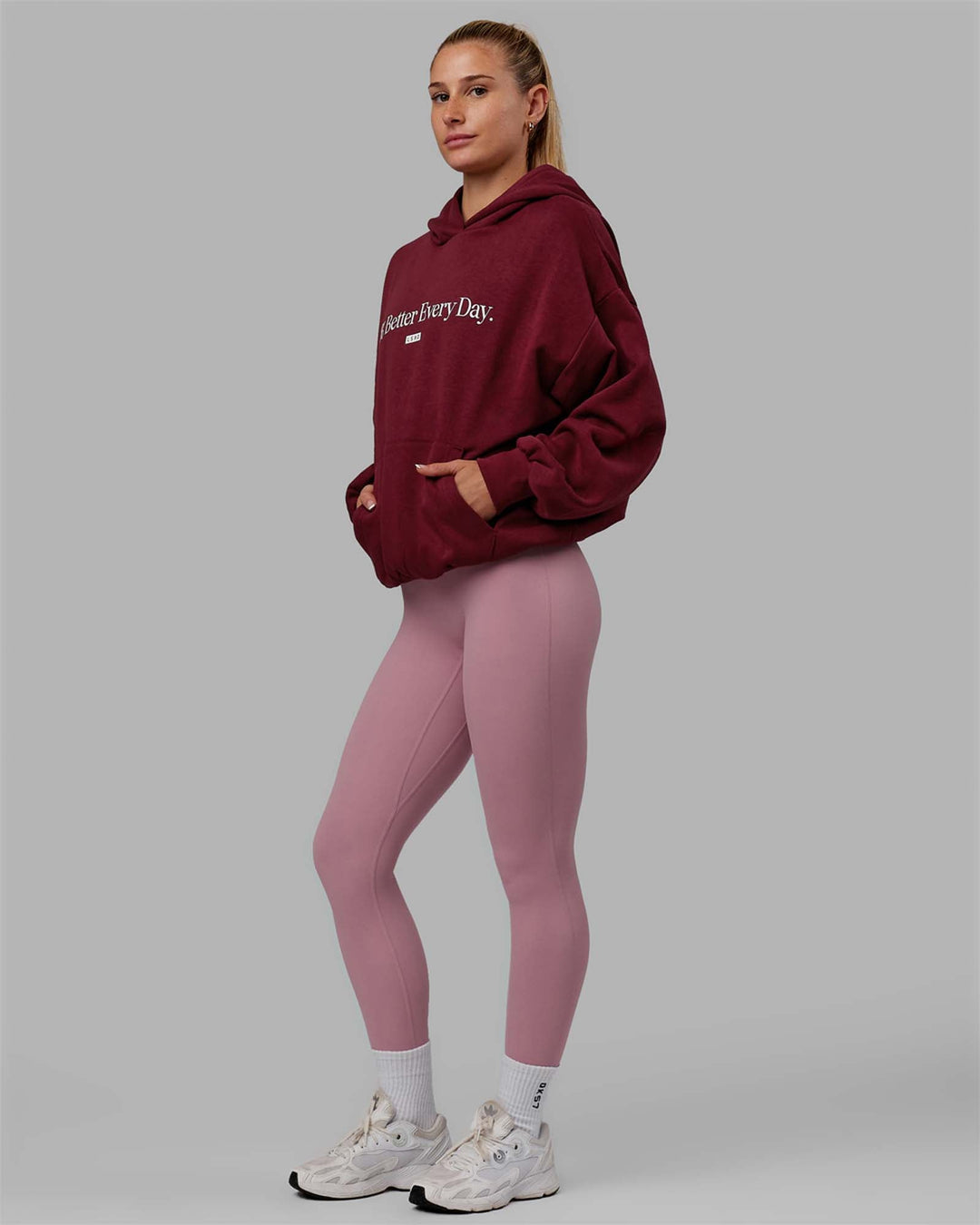 Woman wearing Unisex 1% Better Hoodie Oversize - Cranberry-White