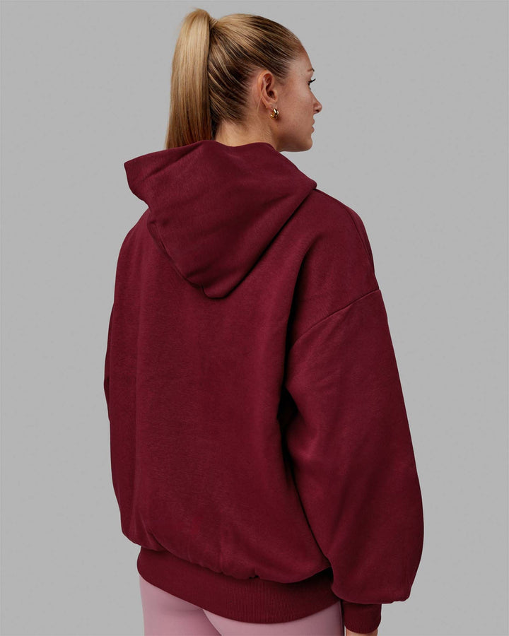 Woman wearing Unisex 1% Better Hoodie Oversize - Cranberry-White