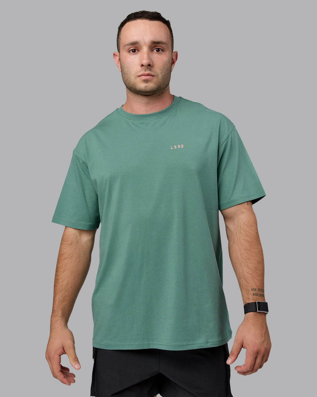 Man wearing Unisex 1% Better Value Series FLXCotton Tee Oversize - Sagebrush-Mellow Peach