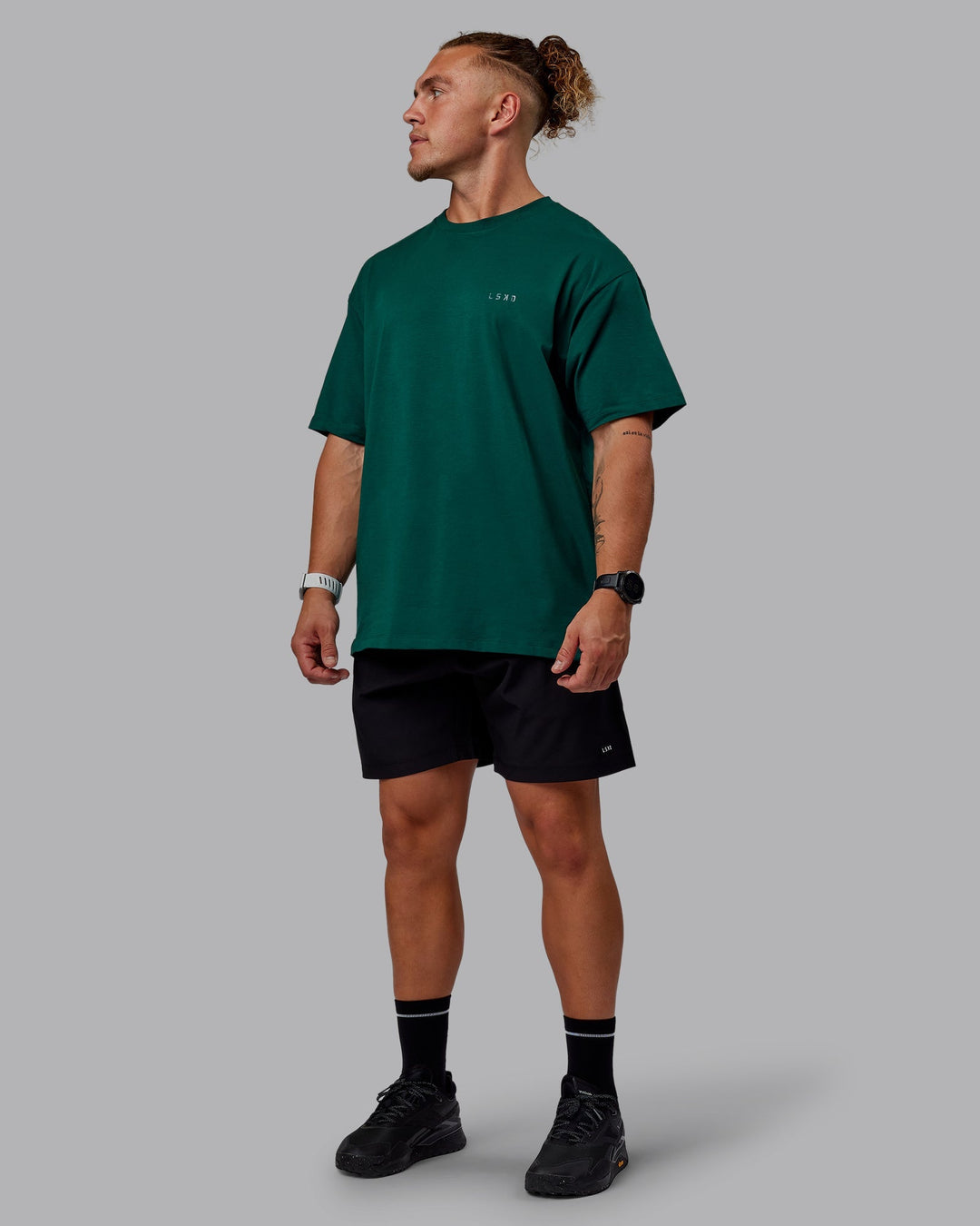 Man wearing Unisex Deluxe PimaFLX Tee Oversize - Deep Emerald