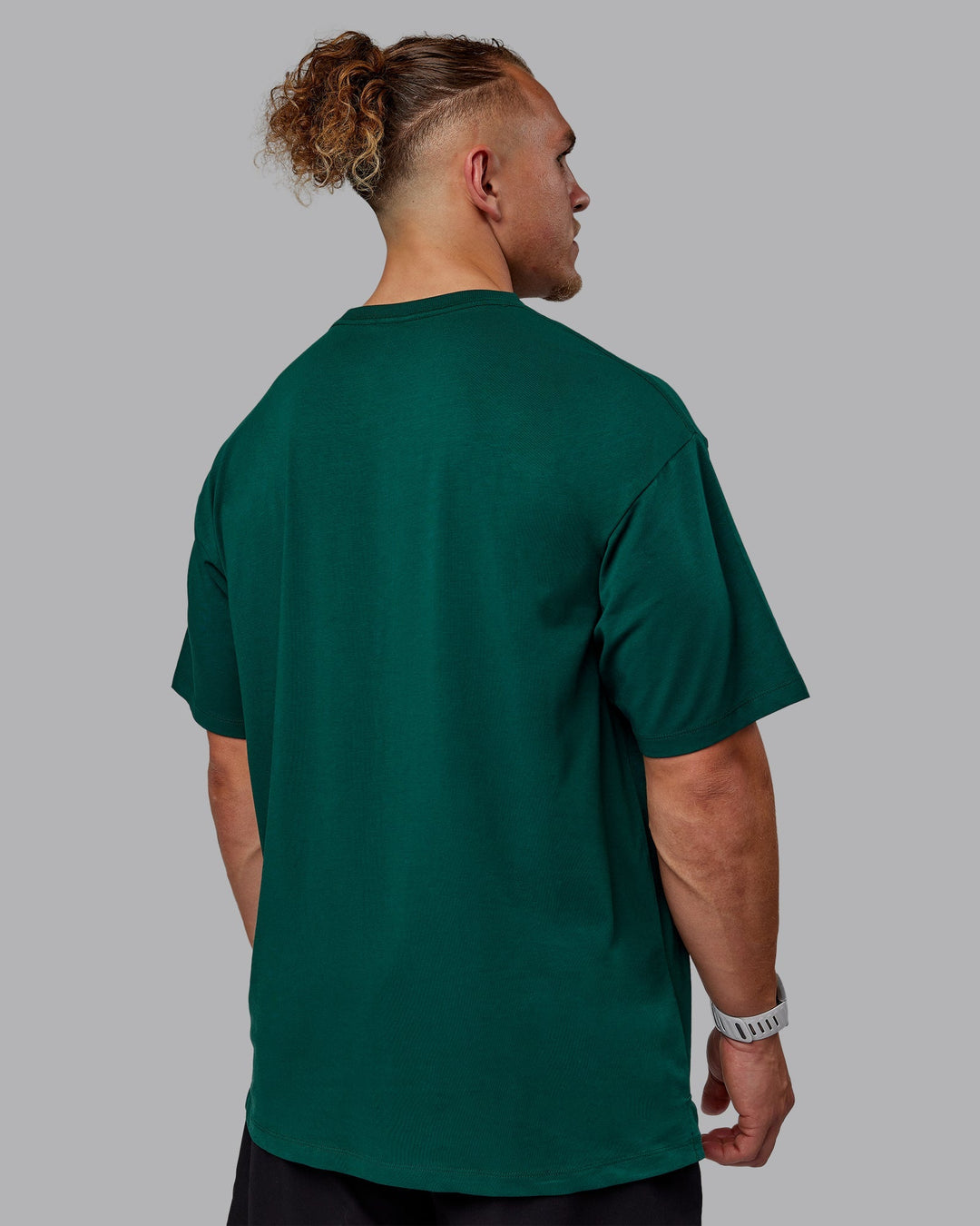 Man wearing Unisex Deluxe PimaFLX Tee Oversize - Deep Emerald