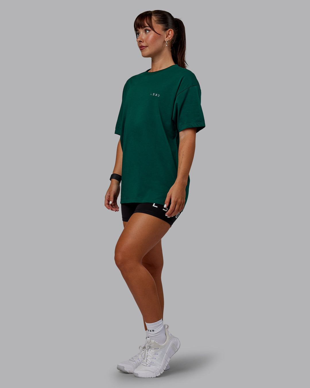 Woman wearing Unisex Deluxe PimaFLX Tee Oversize - Deep Emerald