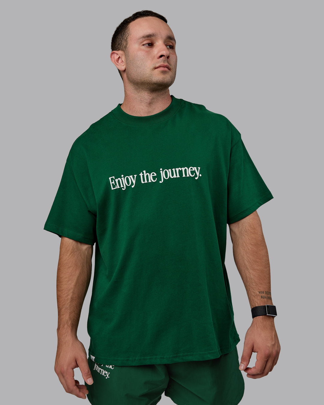 Man wearing Unisex Enjoy The Journey Heavyweight Tee Oversize - Deep Emerald-Off-White