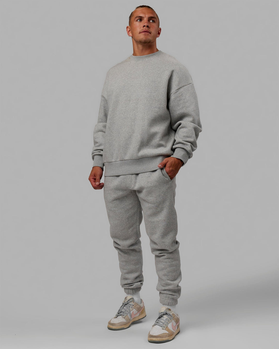 Man wearing Unisex MVP Sweater Oversize - Light Grey Marl