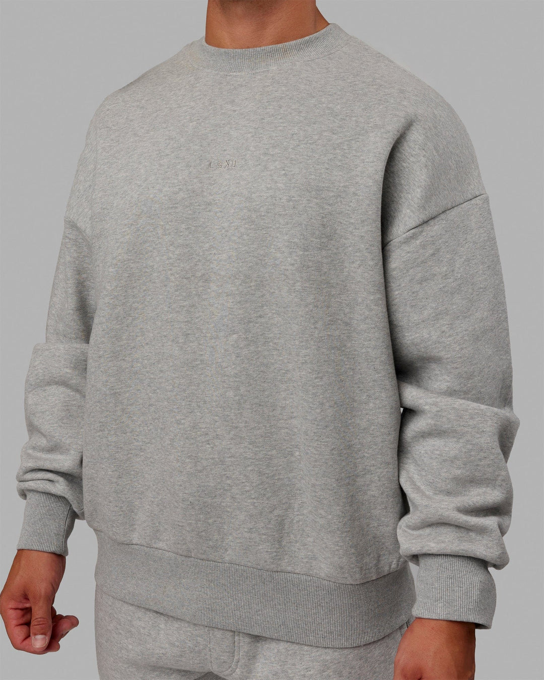 Man wearing Unisex MVP Sweater Oversize - Light Grey Marl