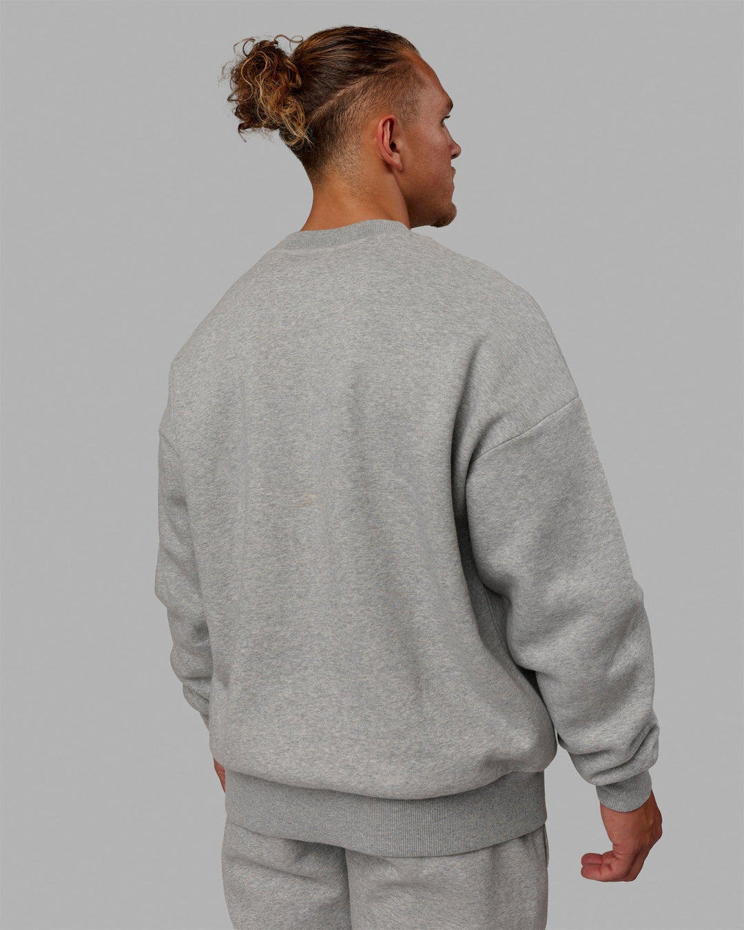 Man wearing Unisex MVP Sweater Oversize - Light Grey Marl