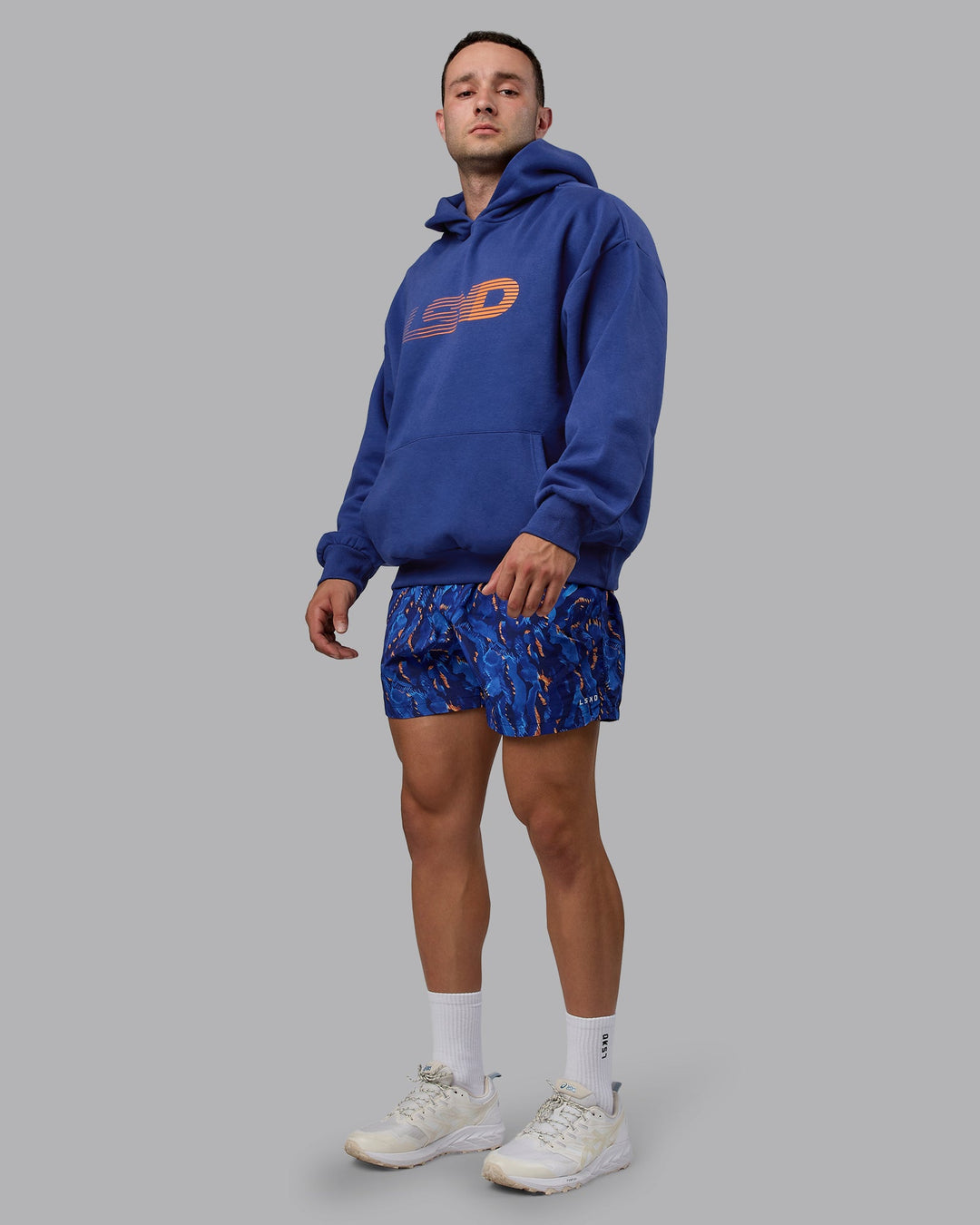 Man wearing Unisex Motion Hoodie Oversize - Galactic Cobalt-Vibrant Orange