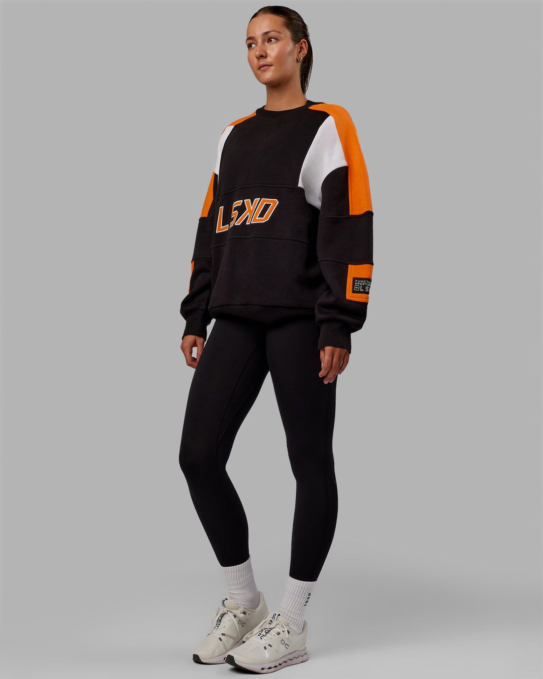 Woman wearing Unisex Slam Sweater Oversize - Black-Ultra Orange