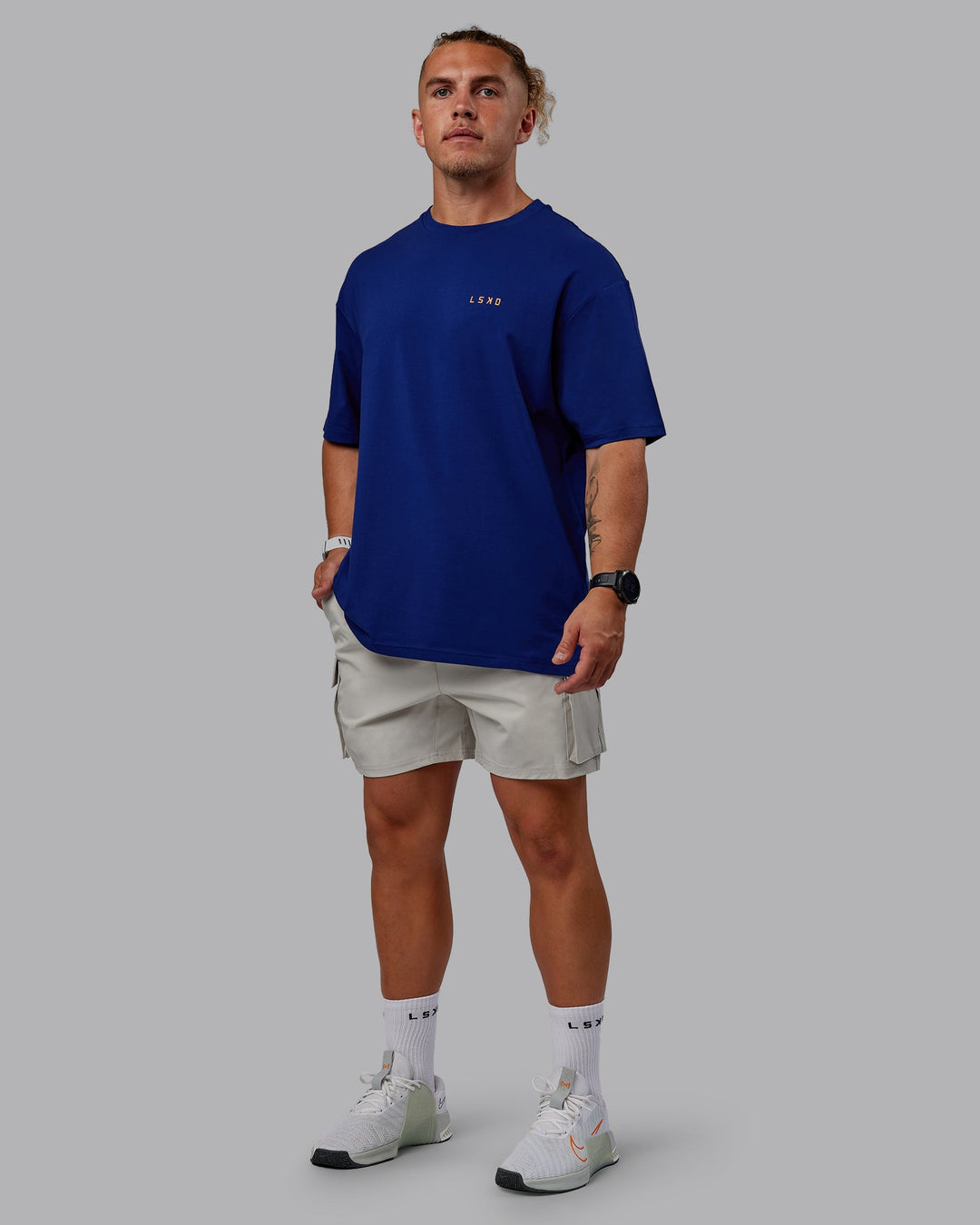 Man wearing Unisex Strike Through FLXCotton Tee Oversize - Midnight Blue-Vibrant Orange