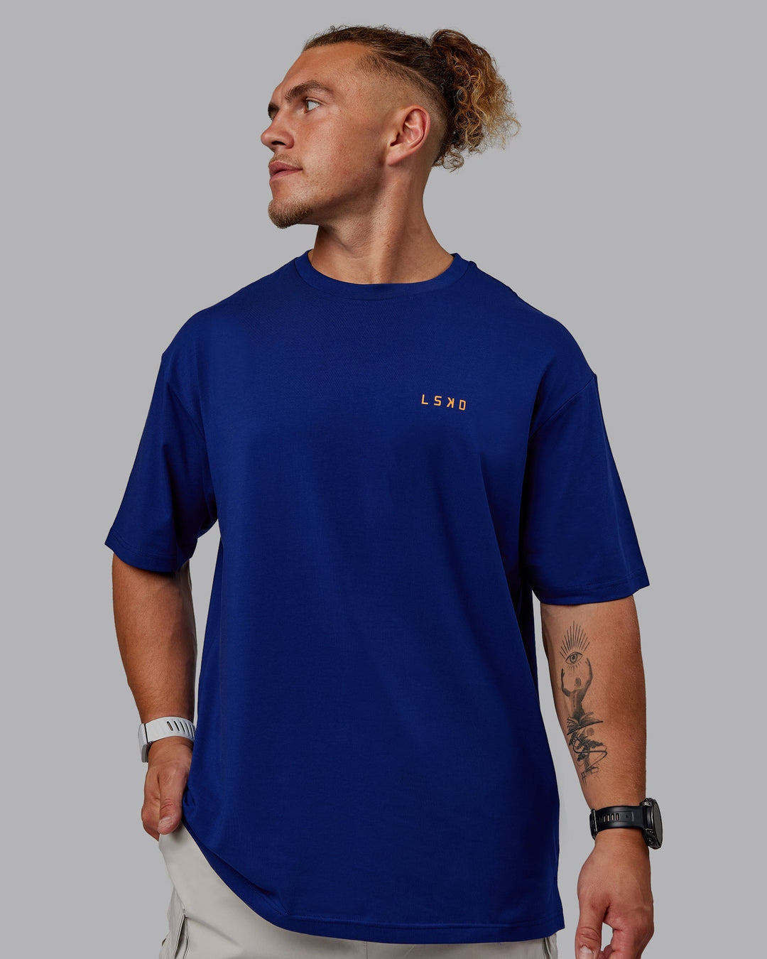 Man wearing Unisex Strike Through FLXCotton Tee Oversize - Midnight Blue-Vibrant Orange