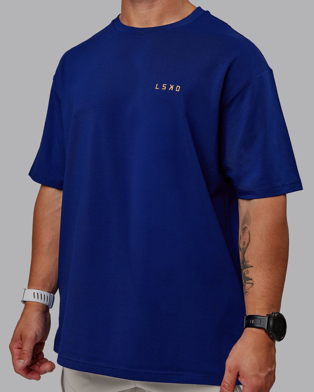 Man wearing Unisex Strike Through FLXCotton Tee Oversize - Midnight Blue-Vibrant Orange