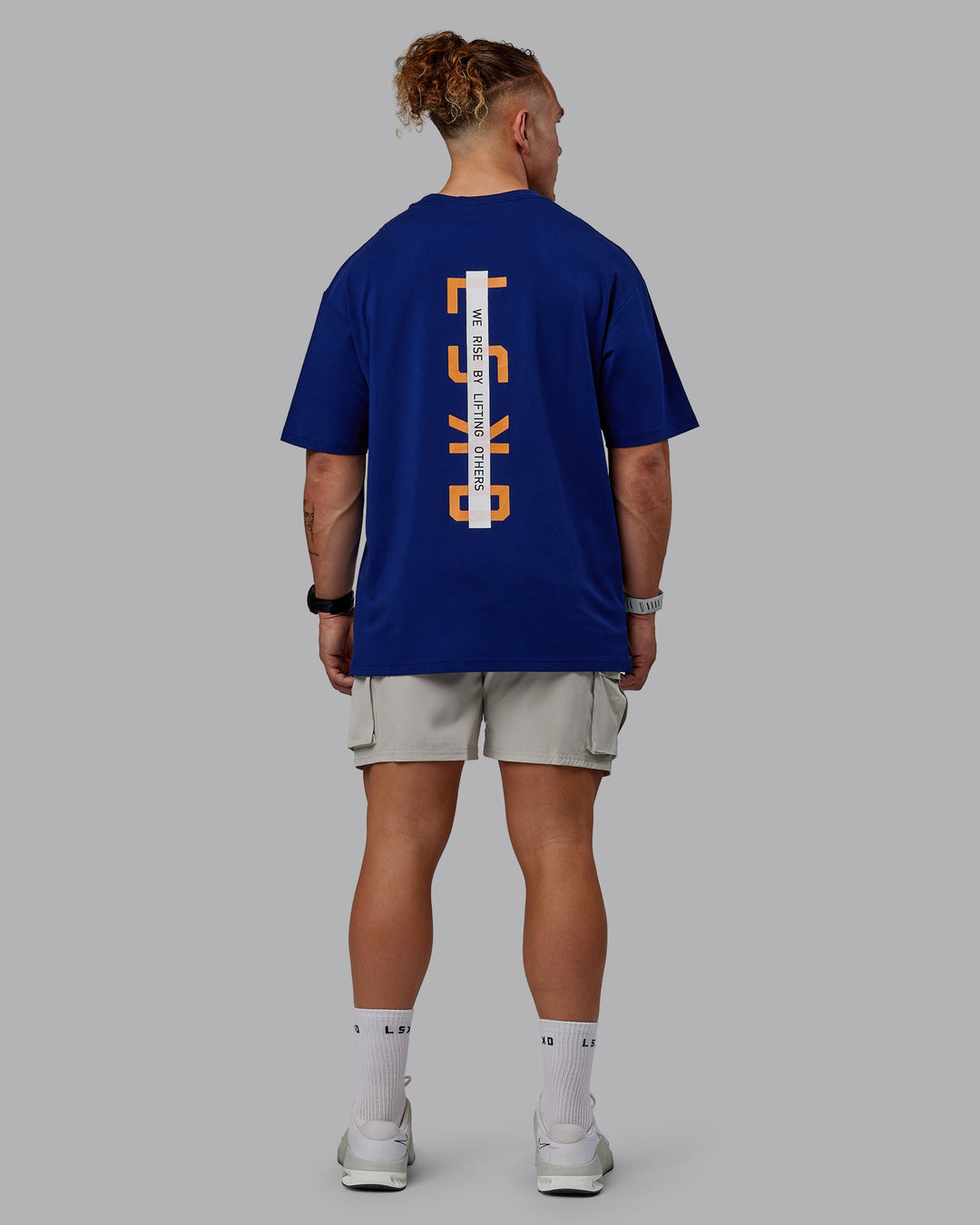 Man wearing Unisex Strike Through FLXCotton Tee Oversize - Midnight Blue-Vibrant Orange