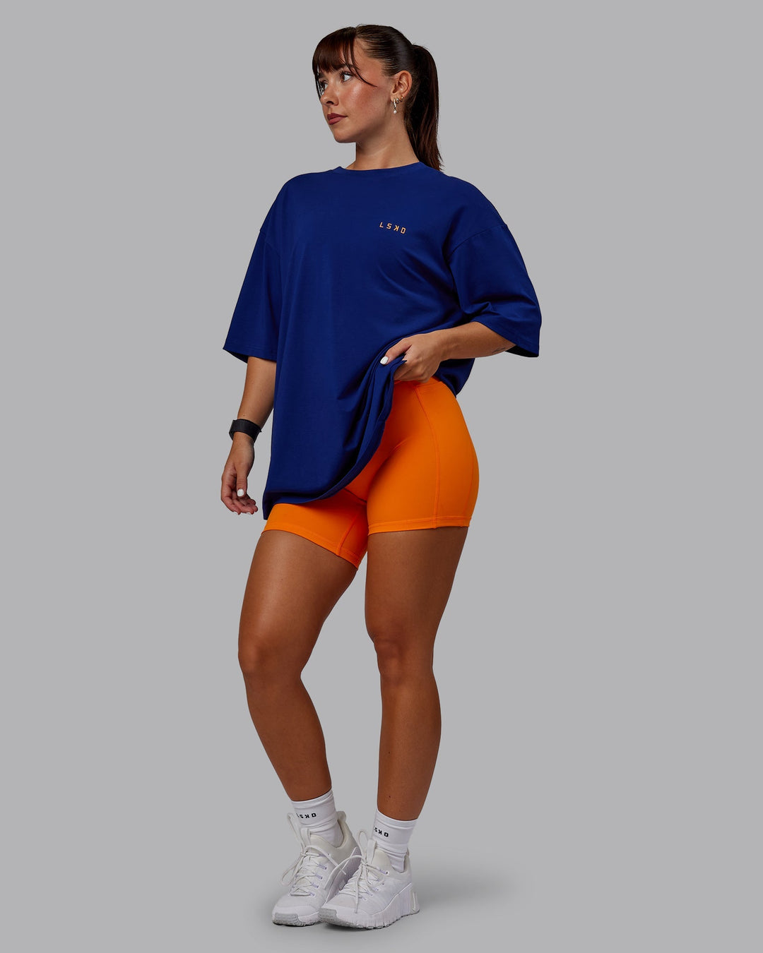 Woman wearing Unisex Strike Through FLXCotton Tee Oversize - Midnight Blue-Vibrant Orange