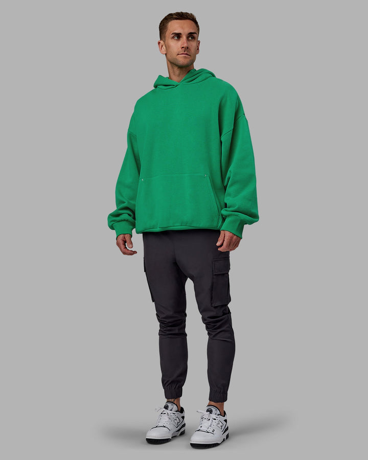 Man wearing Unisex We Rise Hoodie Oversize - Impact Green-White
