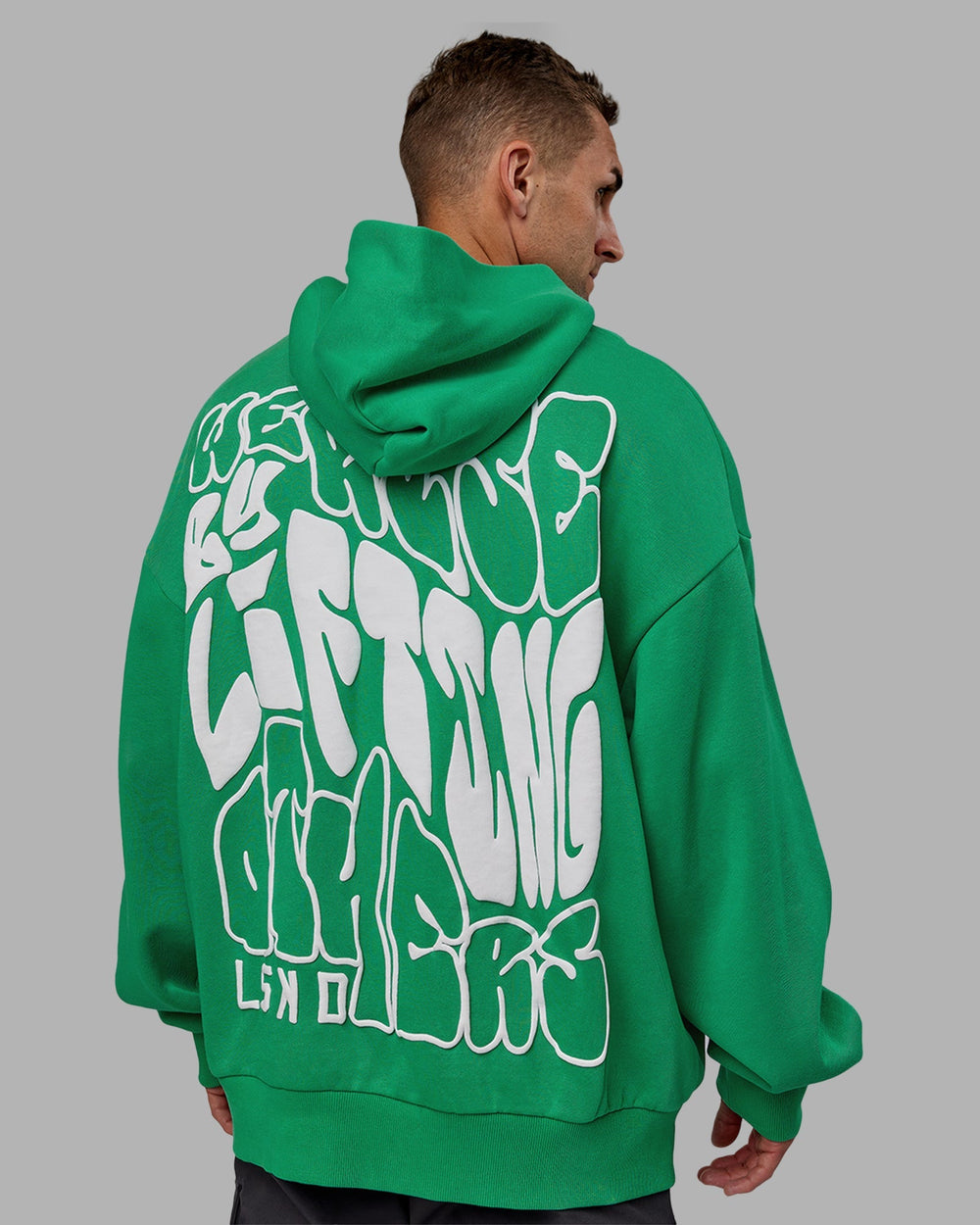 Man wearing Unisex We Rise Hoodie Oversize - Impact Green-White