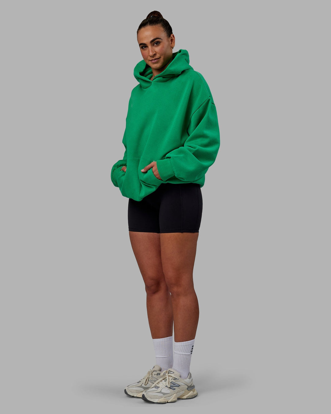 Woman wearing Unisex We Rise Hoodie Oversize - Impact Green-White