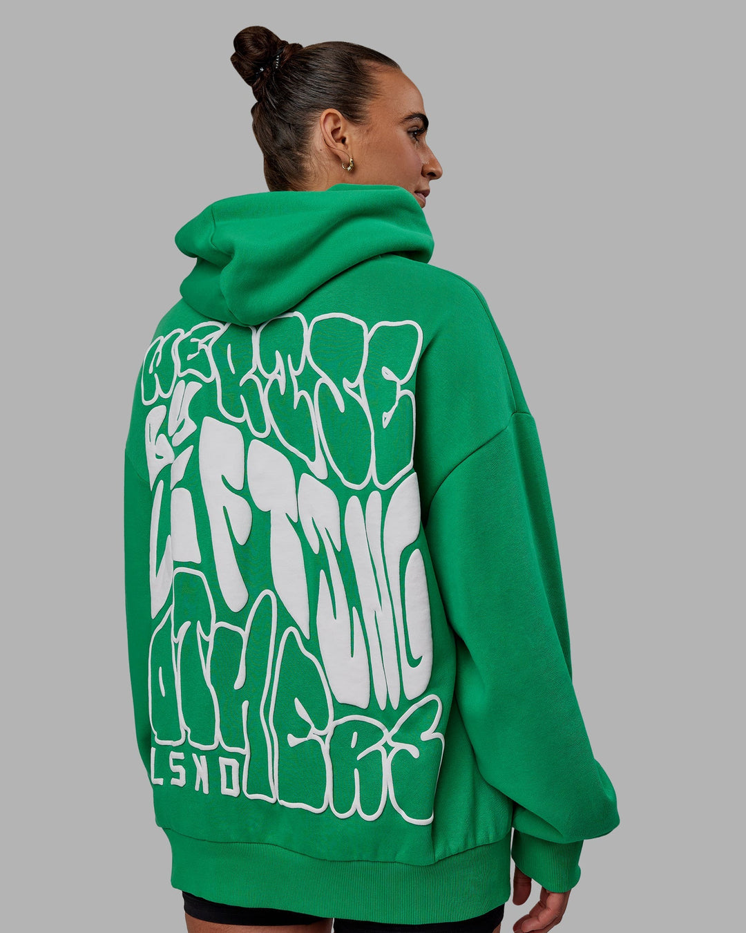 Woman wearing Unisex We Rise Hoodie Oversize - Impact Green-White