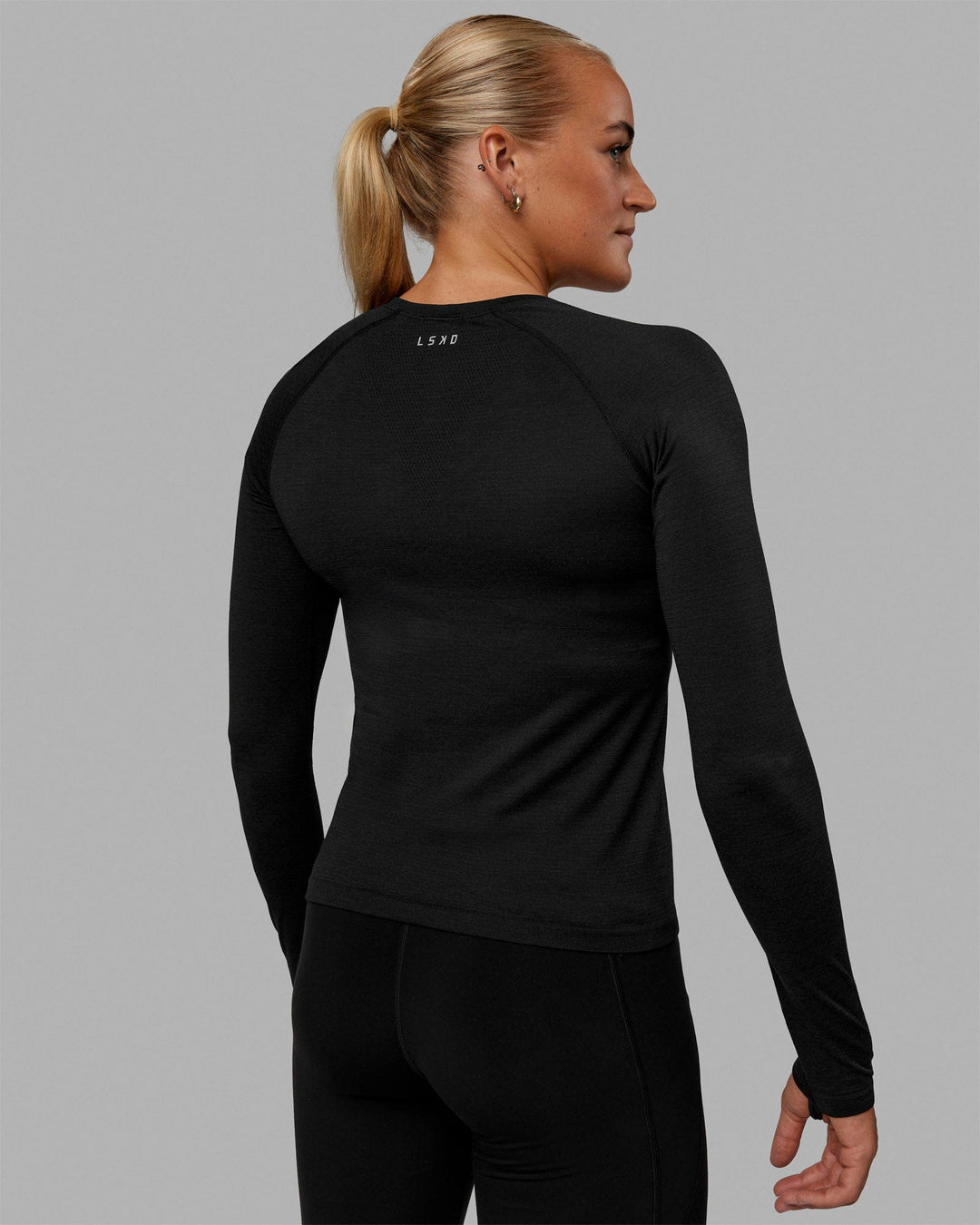 Woman wearing AeroFLX+ Seamless Long Sleeve Tee - Black Marl