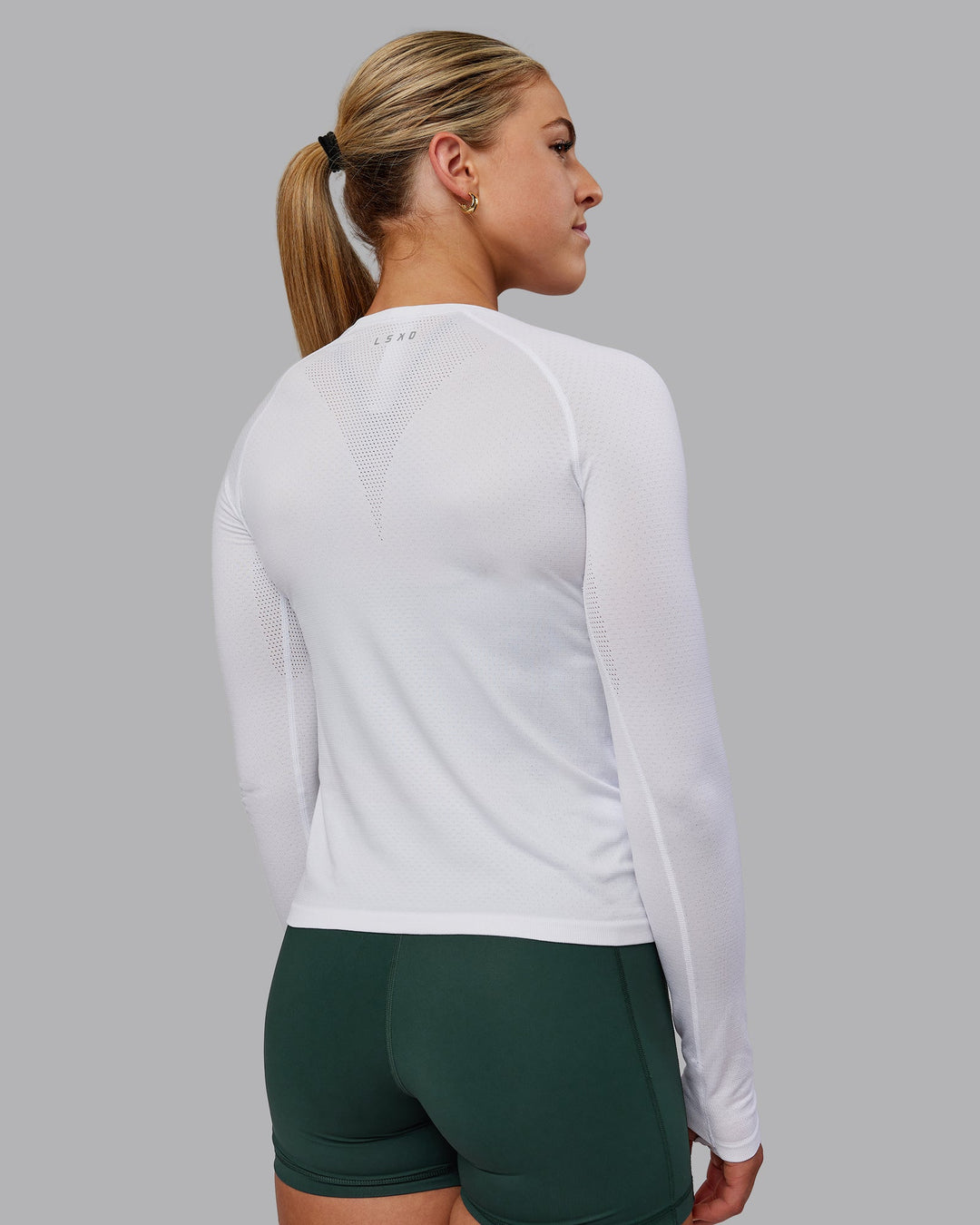 Woman wearing AeroFLX+ Seamless Long Sleeve Tee - White/White