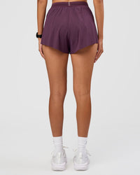 Woman wearing Accelerate 3" High-Rise Running Short - Midnight Plum | Set:true | Angle:back | Model:Rhiley | Size:S