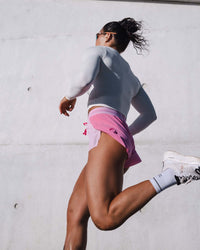 Woman wearing Accelerate 3" Mid-Rise Running Short - Candy Pink-Marshmallow | Model:Emily | Size:S