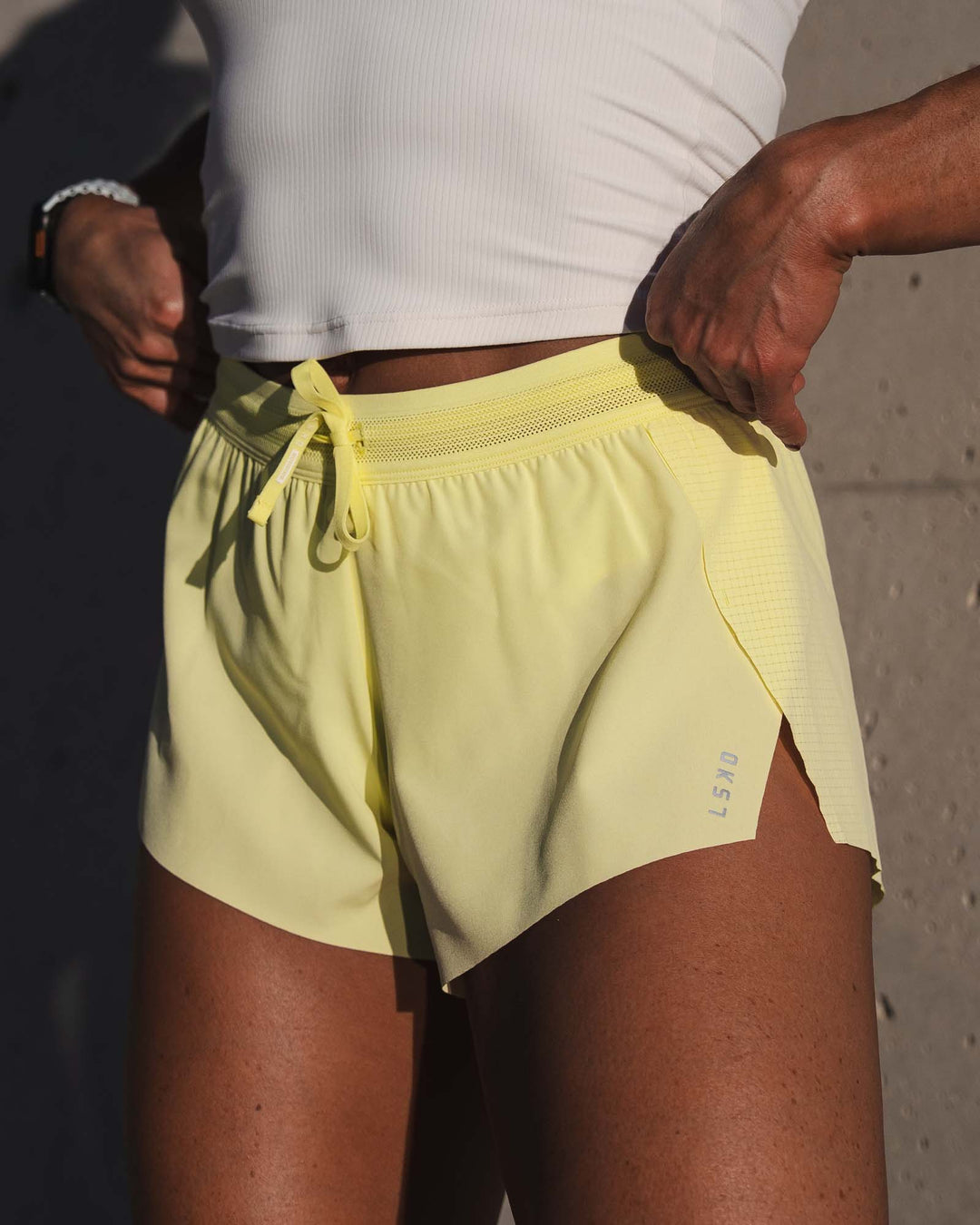 Woman wearing Accelerate 3" Mid-Rise Running Short - Yellow Fizz | Model:Emily | Size:S
