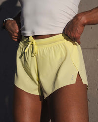 Woman wearing Accelerate 3" Mid-Rise Running Short - Yellow Fizz | Model:Emily | Size:S