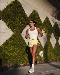 Woman wearing Accelerate 3" Mid-Rise Running Short - Yellow Fizz | Model:Emily | Size:S
