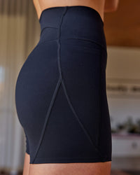 Woman wearing Elixir Defined High-Rise 6" Short Pockets - Black | Model:Shae | Size:S