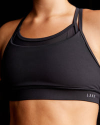 Woman wearing Genesis Layered Sports Bra - Black | Size:S